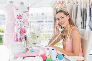 Female fashion designer using phone in studio