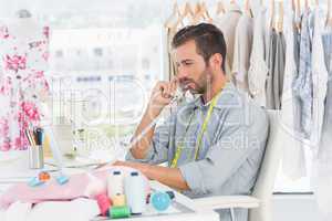 Young male fashion designer using phone