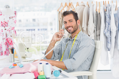 Portrait of a young male fashion designer using phone