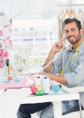 Portrait of a young male fashion designer using phone