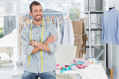 Smiling male fashion designer with arms crossed