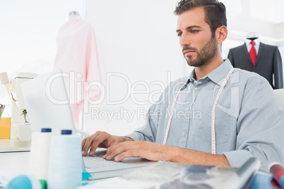 Young male fashion designer using laptop