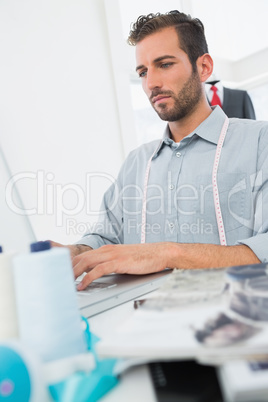 Young male fashion designer using laptop
