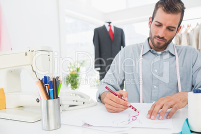 Fashion designer working on his designs in studio