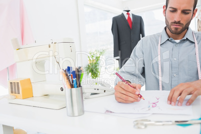 Fashion designer working on his designs in studio