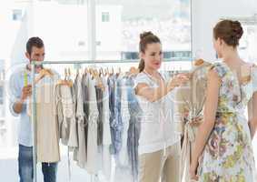 Seller helping shopper choose clothes in store