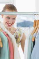 Beautiful female customer selecting clothes at store