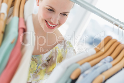 Beautiful female customer selecting clothes at store