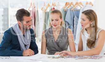Three fashion designers discussing designs
