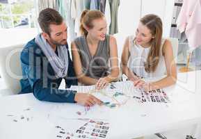 Three fashion designers discussing designs