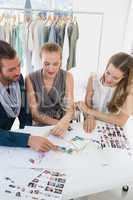 Three fashion designers discussing designs