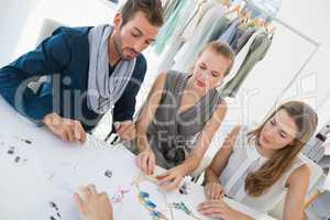 Three fashion designers discussing designs