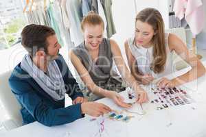 Three fashion designers discussing designs