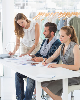 Three fashion designers discussing designs