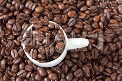 espressotasse steht zwischen vielen kaffeebohnen