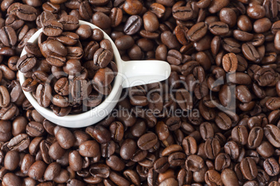 espressotasse umgeben von vielen kaffeebohnen