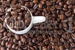 espressotasse umgeben von vielen kaffeebohnen