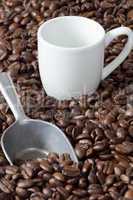 espressotasse und kaffeeschaufel zwischen kaffeebohnen