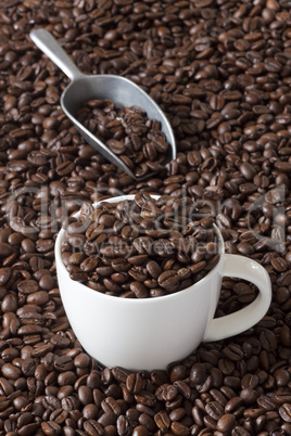 kaffeetasse mit kaffeebohnen und eine kaffeeschaufel