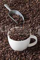 kaffeetasse mit kaffeebohnen und eine kaffeeschaufel