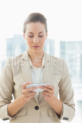 Beautiful young businesswoman text messaging