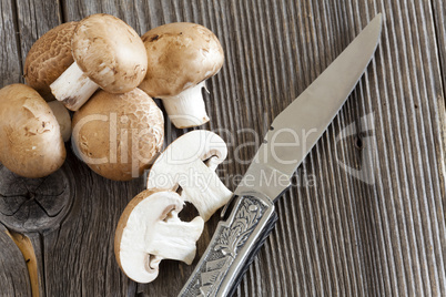 jagdmesser und champignons auf holz