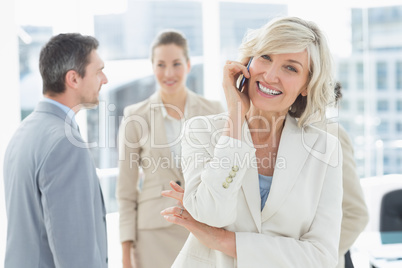 Mature businesswoman on call with colleagues at office