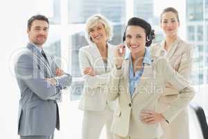 Businesswoman wearing headset with colleagues in office
