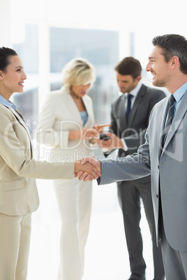 Executives shaking hands in office