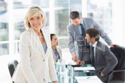 Mature businesswoman with colleagues discussing in office