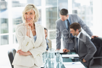 Mature businesswoman with colleagues discussing in office