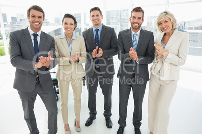 Business team clapping hands together in office