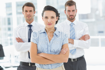 Confident business team with arms crossed in office