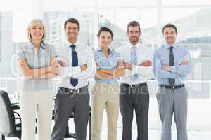 Confident business team with arms crossed in office