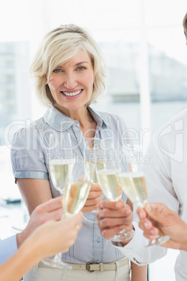 Businesswoman toasting with champagne in office