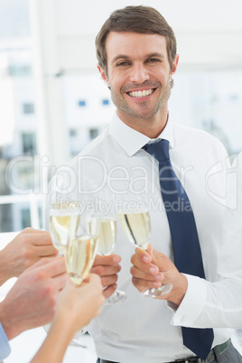 Businessman toasting with champagne in office