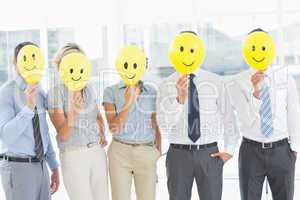 Business people holding happy smiles in front of faces