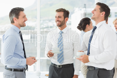 Business colleagues in discussion with tea cups during break