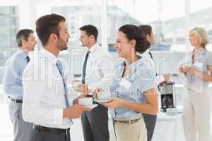 Colleagues in discussion with tea cups during break