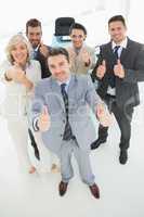 Confident business team gesturing thumbs up