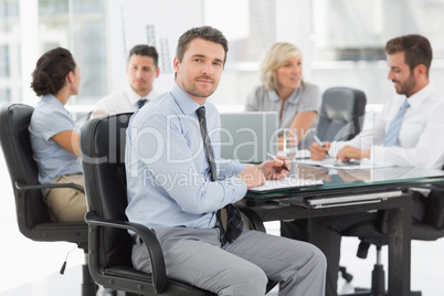 Young businessman with colleagues discussing in office