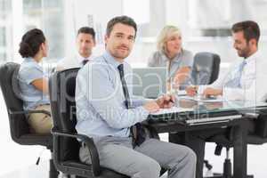 Young businessman with colleagues discussing in office