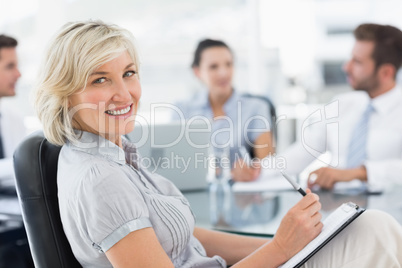 Young businesswoman with colleagues discussing in office