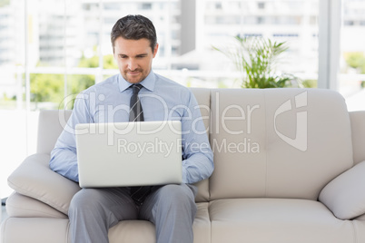 Well dressed man using laptop at home