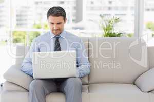 Well dressed man using laptop at home
