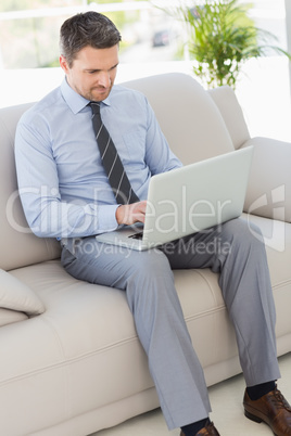 Well dressed man using laptop at home