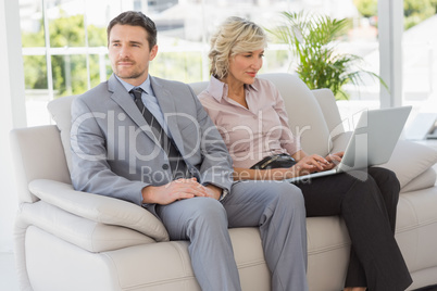 Well dressed man with woman using laptop at home