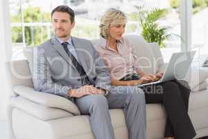 Well dressed man with woman using laptop at home