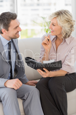 Businessman and his secretary  with diary at home