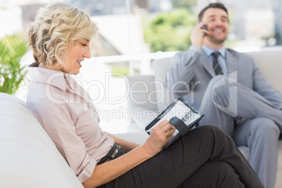 Businessman on call and secretary with diary at home